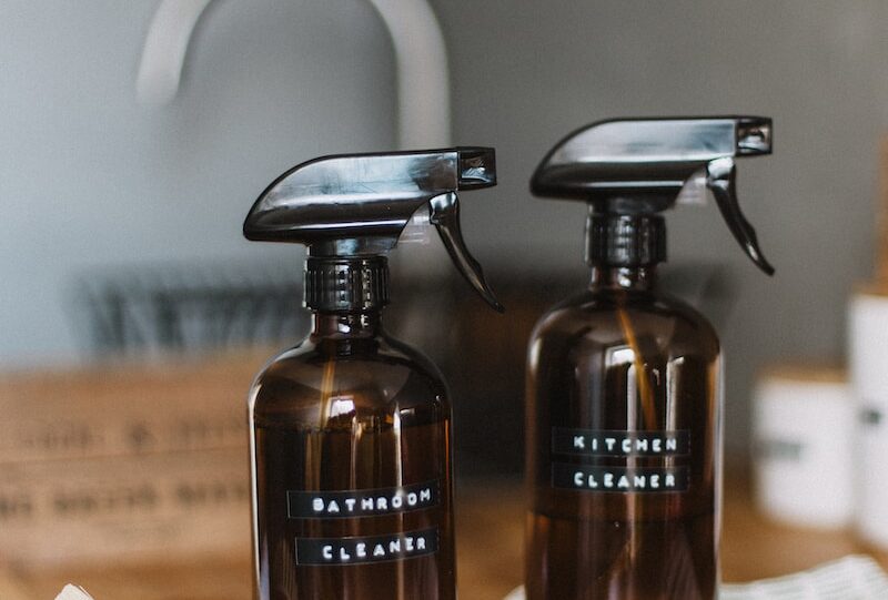 two brown spray bottles on brown table